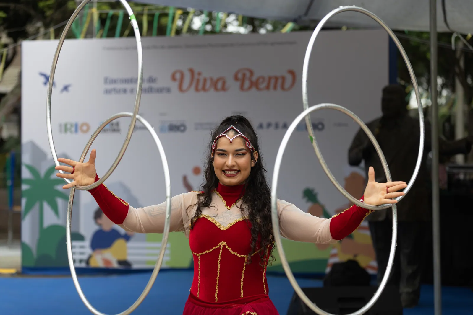 Artista circense com bambolês em apresentação no palco do Encontro Viva Bem, na Tijuca