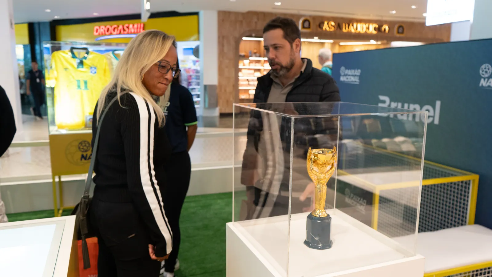 Visitantes diante da réplica da taça Jules Rimet na Exposição Paixão Nacional