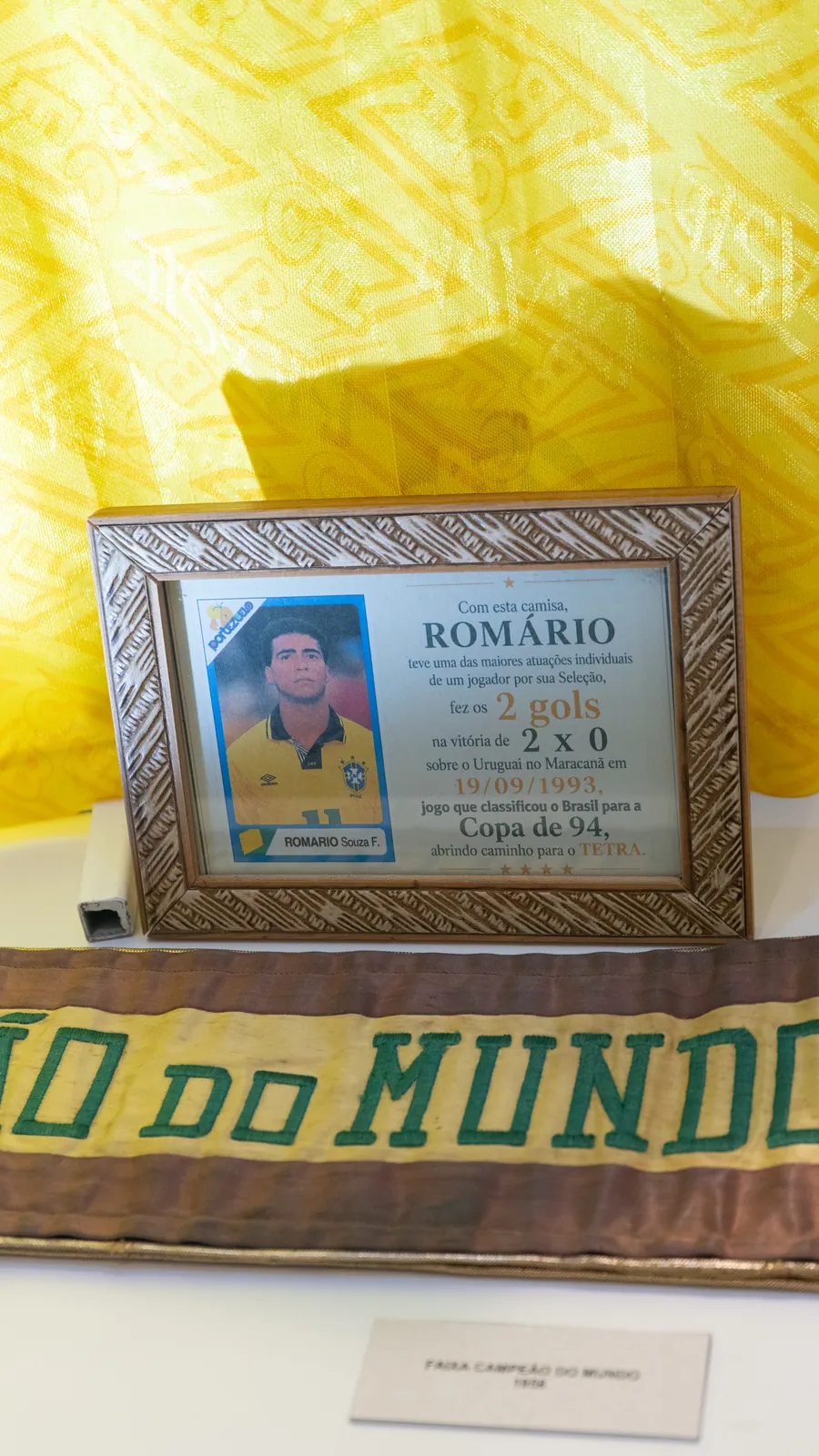 Quadro com figurinha do Romário e faixa de campeão do mundo de 1958 na Paixão Nacional