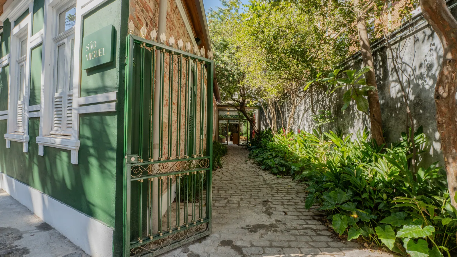 Portão de ferro e caminho de pedras na entrada do restaurante São Miguel, em Botafogo