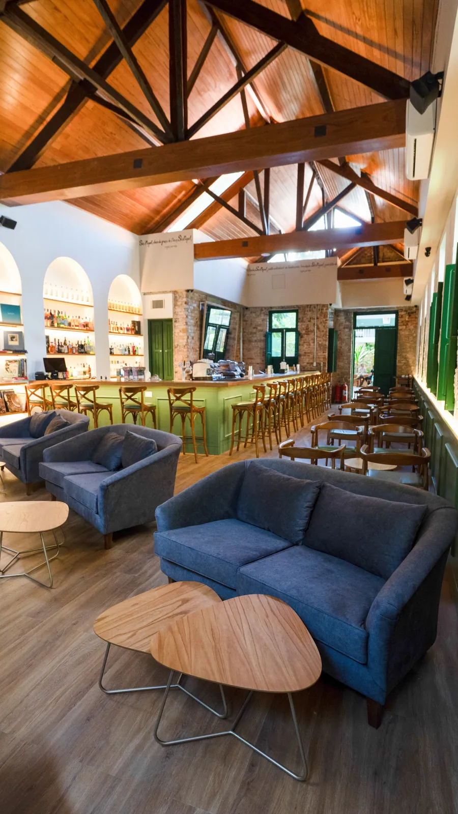 Lounge com sofás azuis ao lado do bar do restaurante São Miguel, em Botafogo